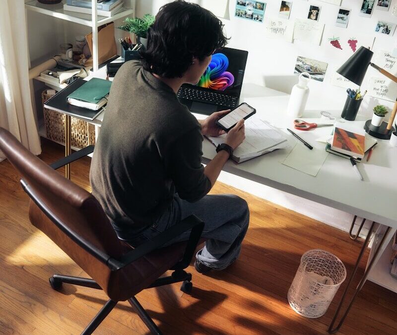 Man working at desk with laptop and phone
